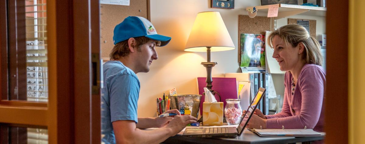 person talking with student in office